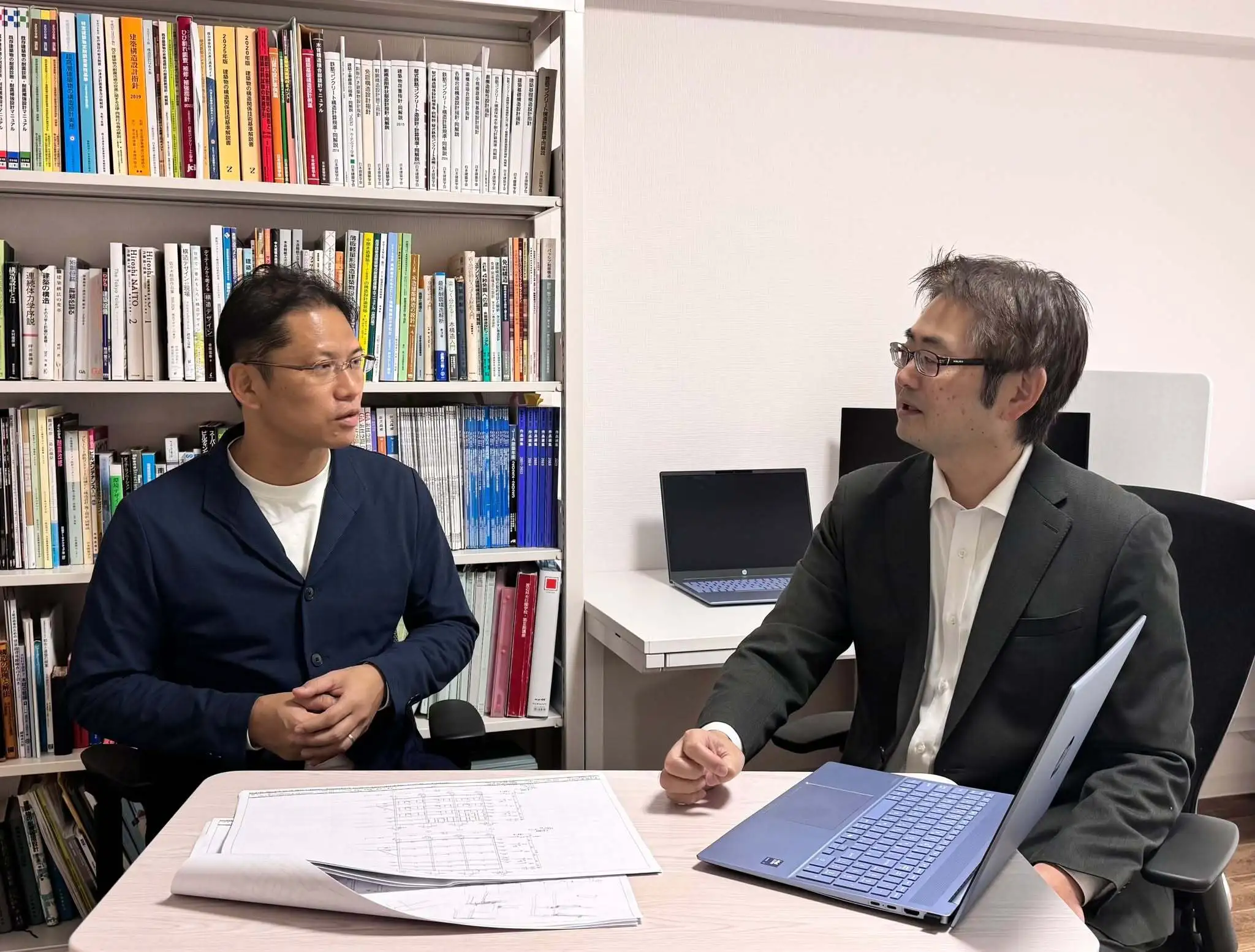 社内での打合せ写真（右:代表者と左:意匠設計者)