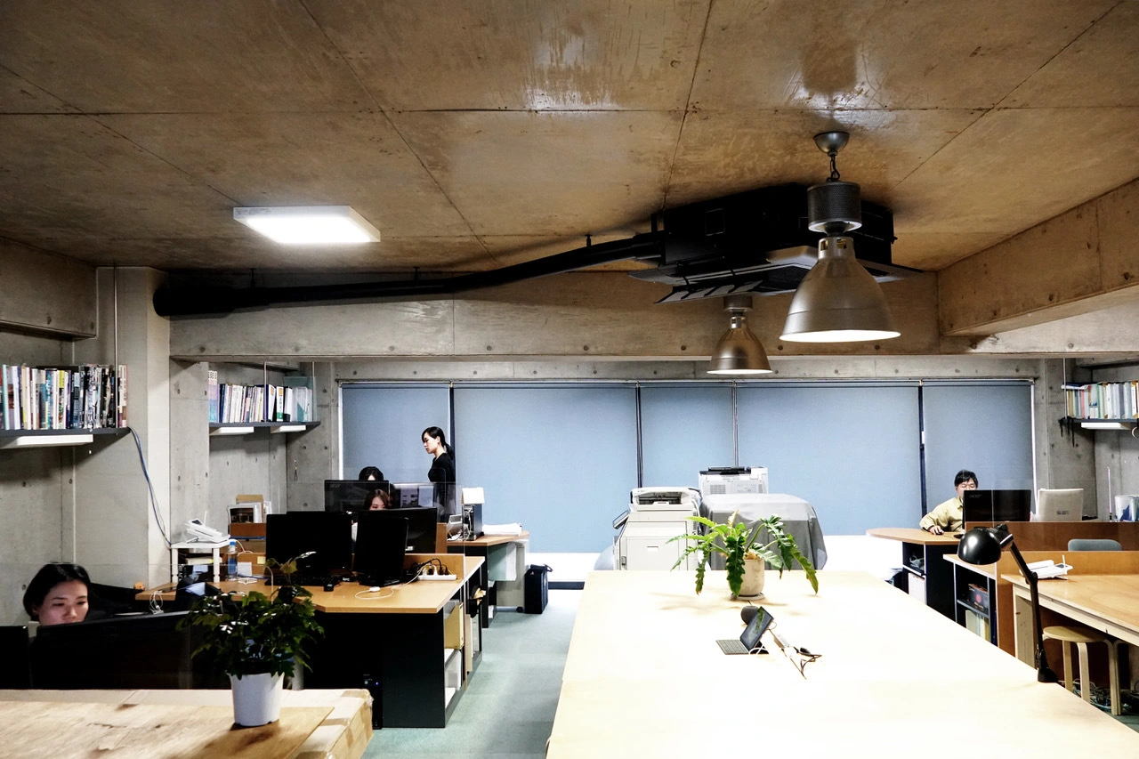 中心にある大きな作業デスクを囲むようにスタッフ全員が１フロアで仕事をしている、風通しの良い環境です。